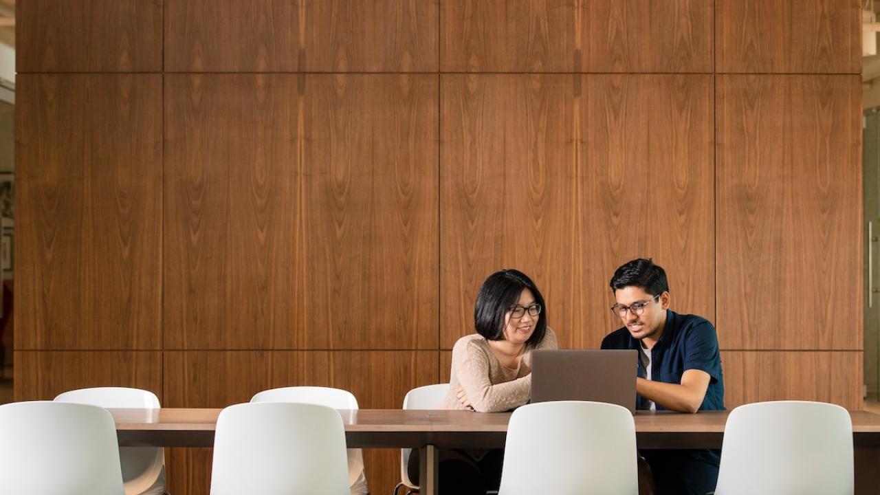 Two GoDaddy employees seated at a conference table.