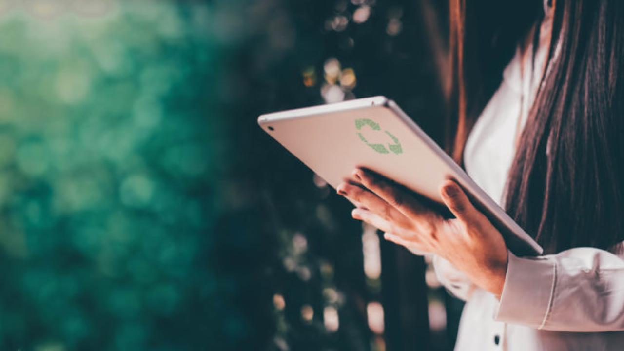 Person standing, looking at tablet