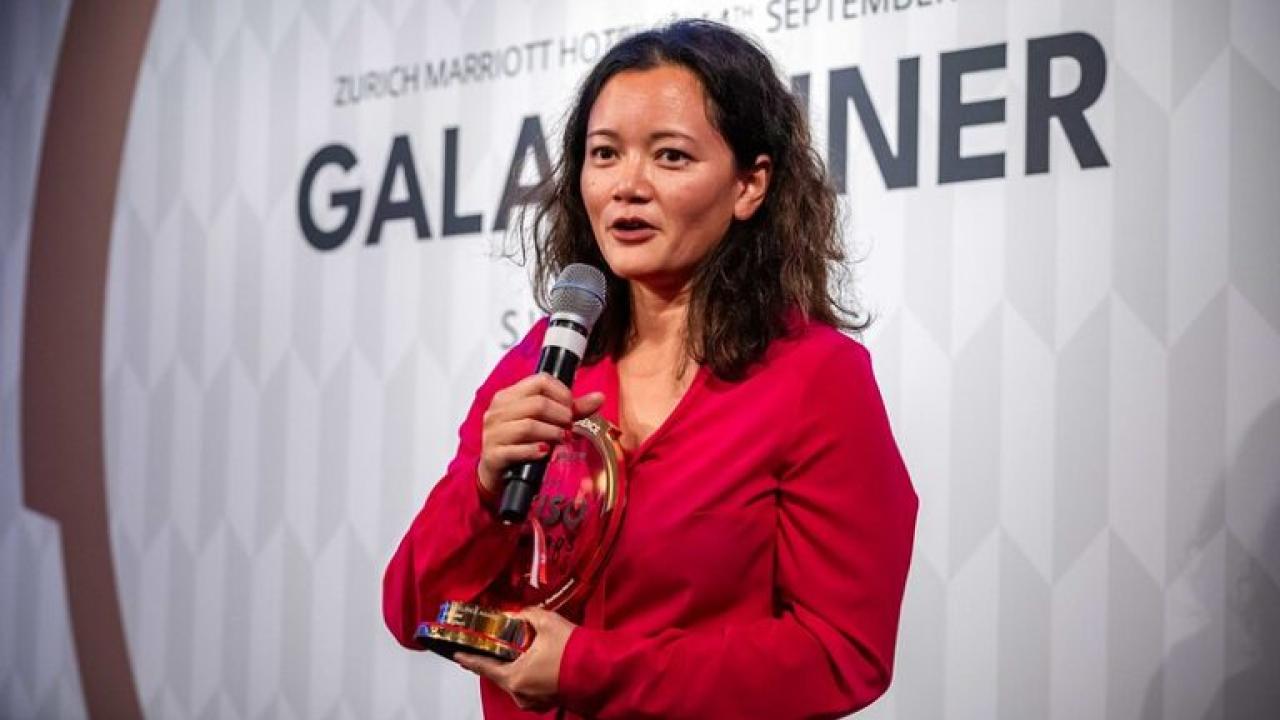 Person holding an award and giving a speech at the Global Cyber Conference 