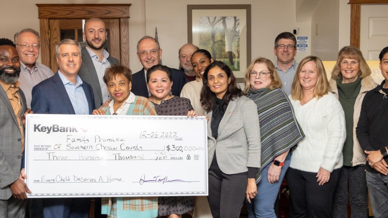 Group of people hold a large KeyBank check