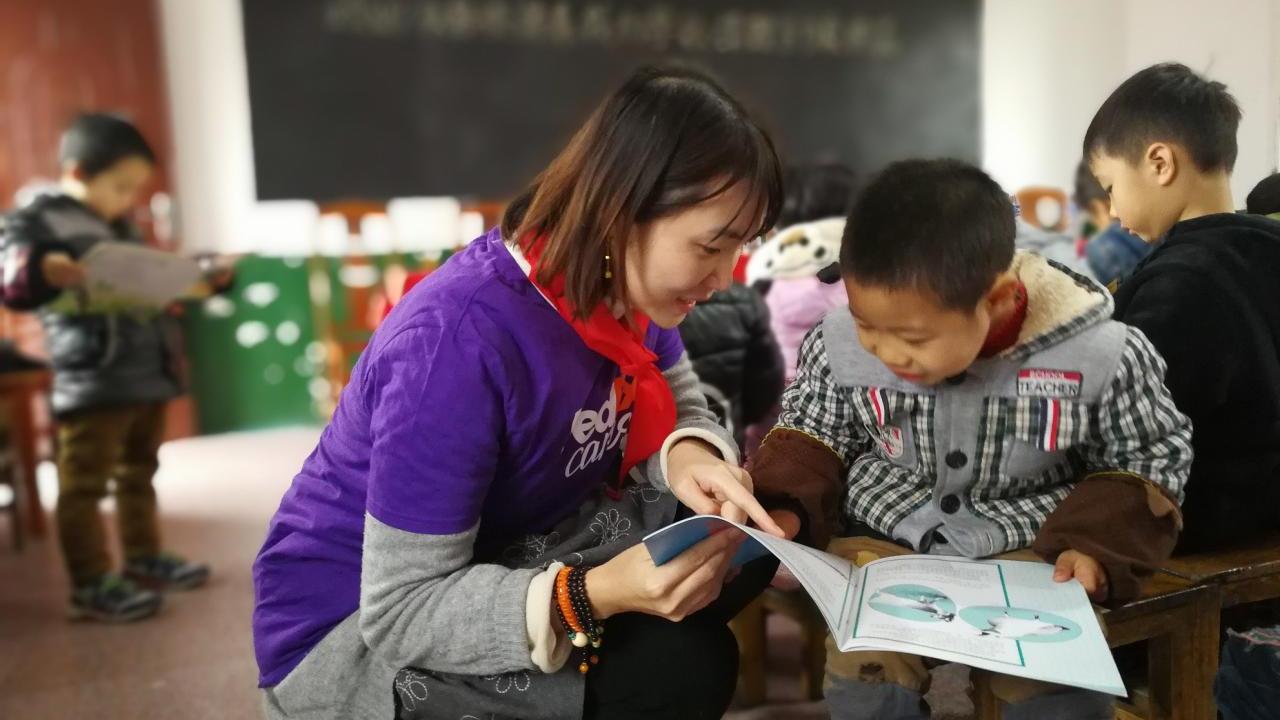 teacher looking at a book with child