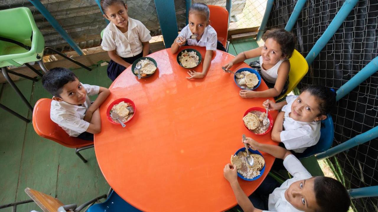 Children eating at small round table together