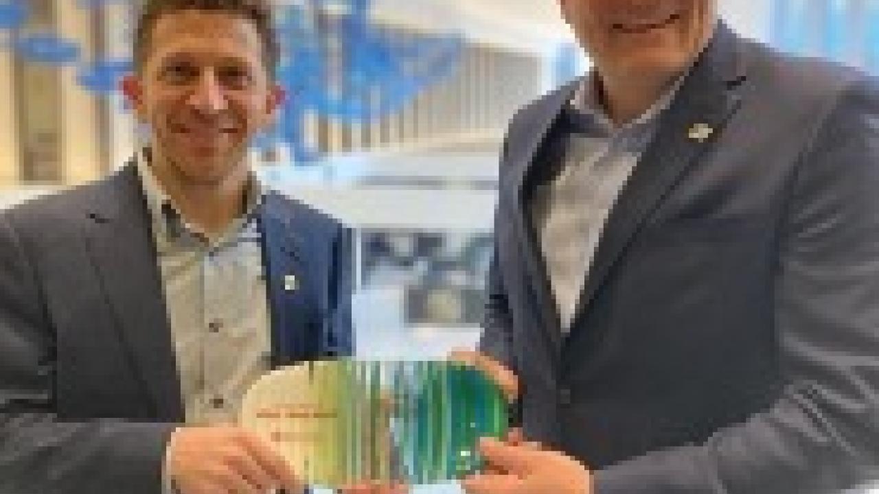 Fifth Third Senior Vice President Thomas Neltner, Enterprise Workplace Services Director and Chief Security Officer, and Fifth Third Vice President & Environmental Sustainability Leader Jeremy Faust (left), hold the Hamilton County R3Source Most Outstanding Partner award, which was made from recycled material.   