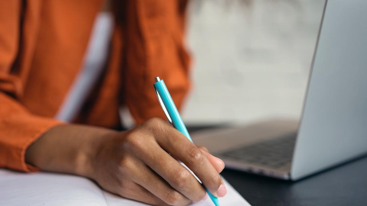 Person shown writing in a notebook.