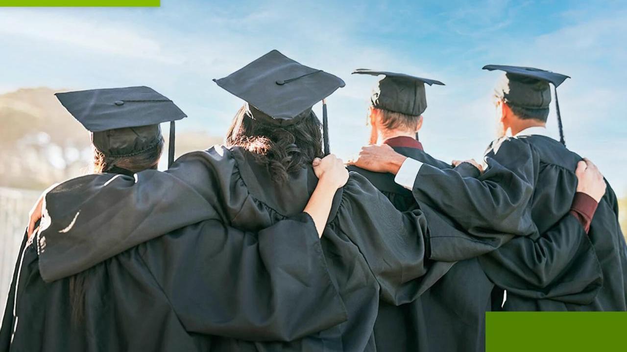 4 people in graduation robes with arms linked