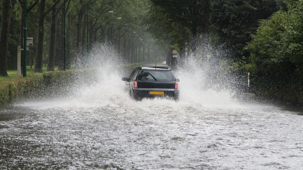 A car driving thorough a flooded street