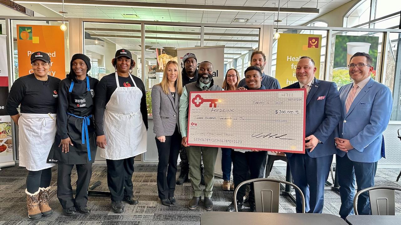 Representatives from KeyBank and Foodlink shown with a $300,000 grant check.