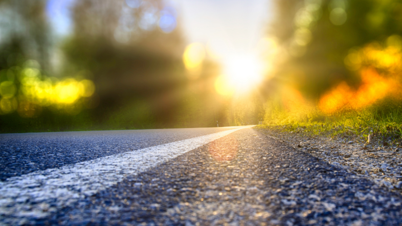 Paved road leads to green horizon
