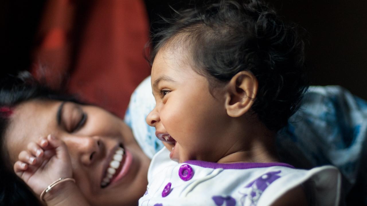 A mother holding her young daughter.