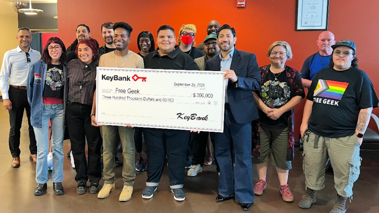 Representatives from Free Geek and KeyBank shown with a grant check for $300,000.