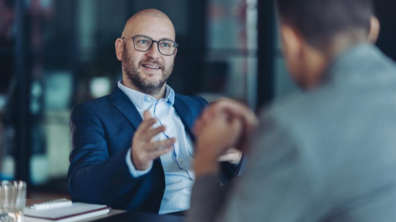 Two men in conversation at a desk
