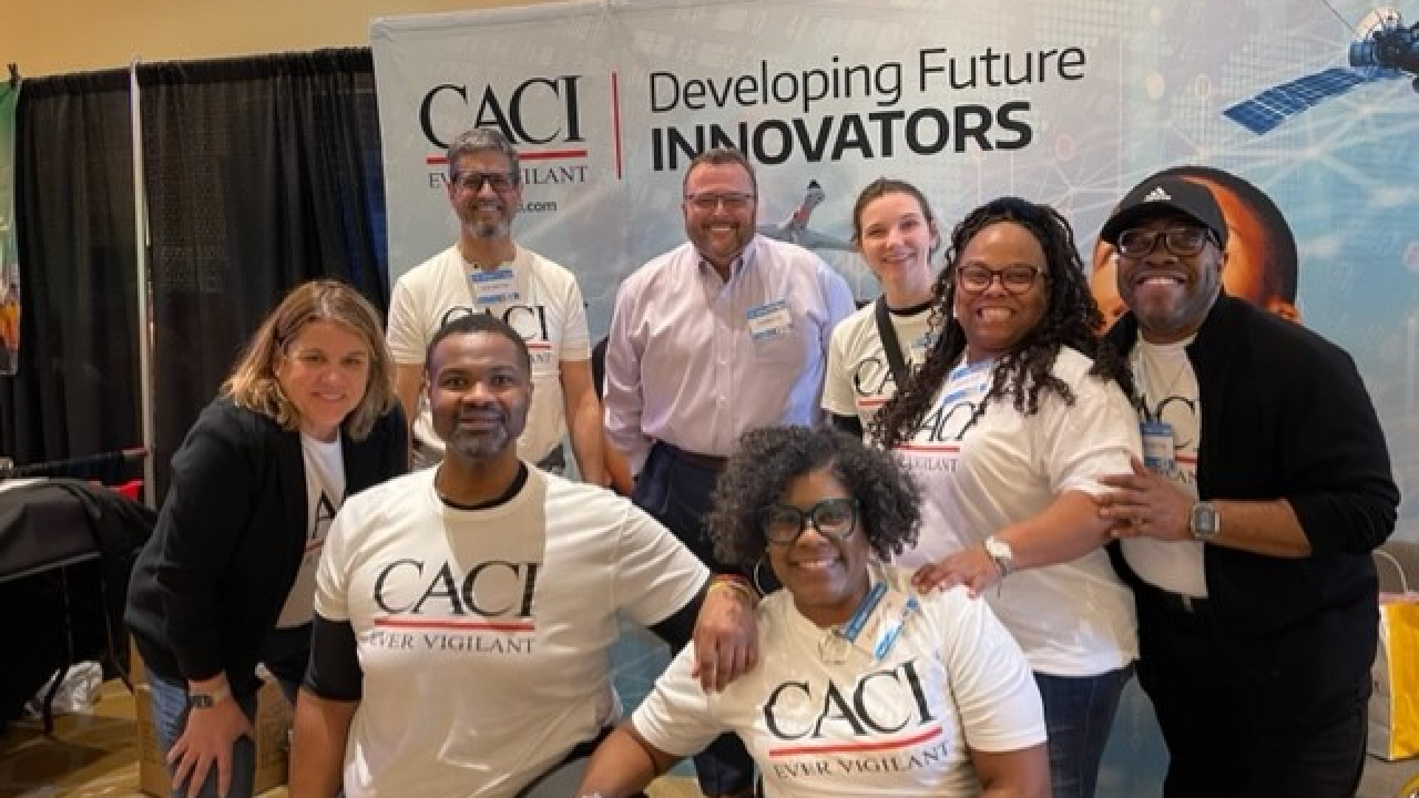 A group posed for the camera wearing matching CACI t-shirts.