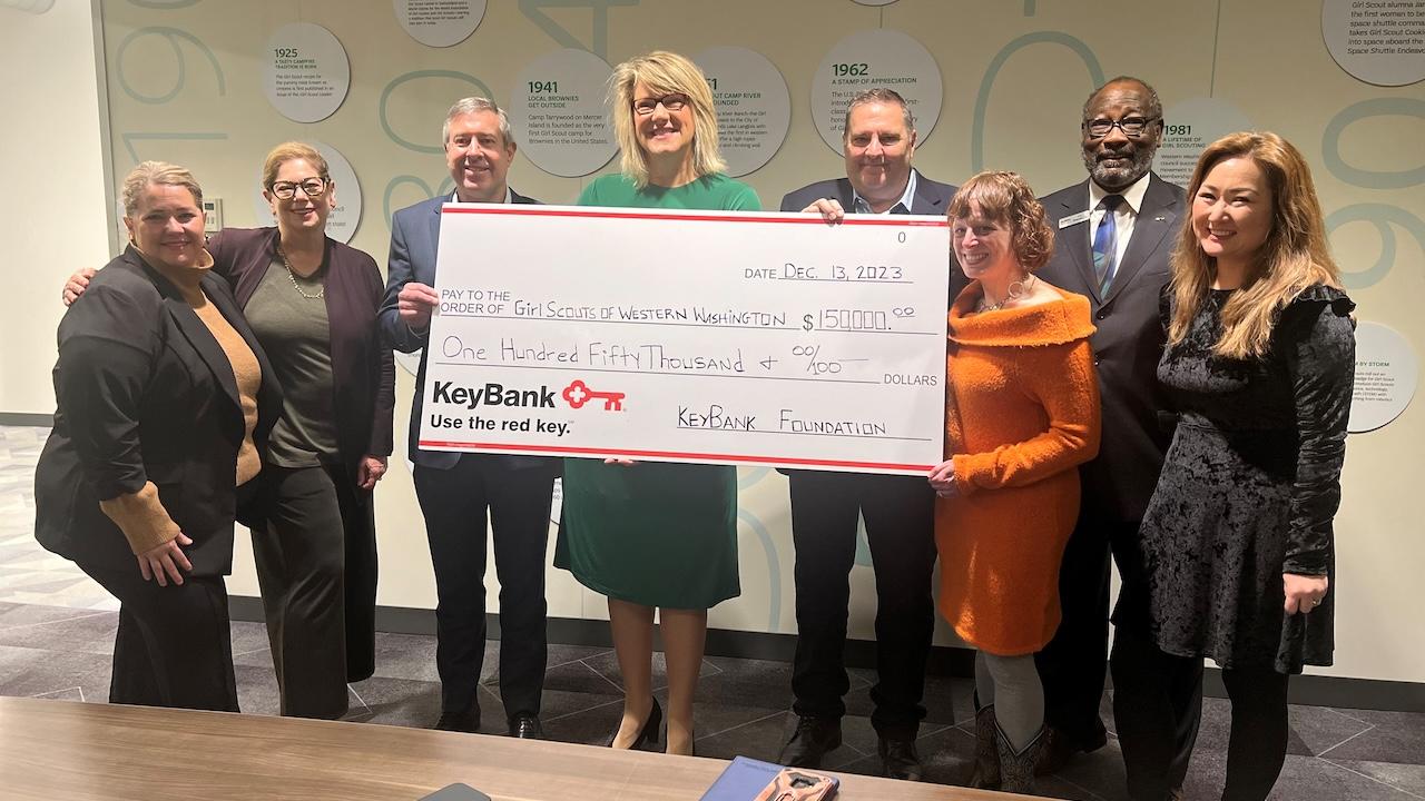 The Girl Scouts of Western Washington accepting a grant check for $150,000 from KeyBank