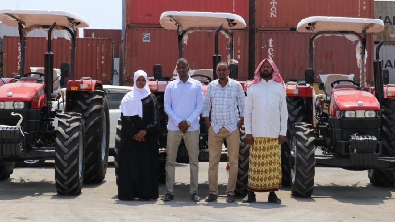 Gaalooge team members standing in front of several tractors