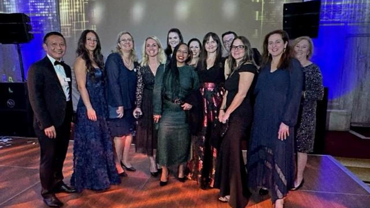 Group of Gala attendees posed on a stage.