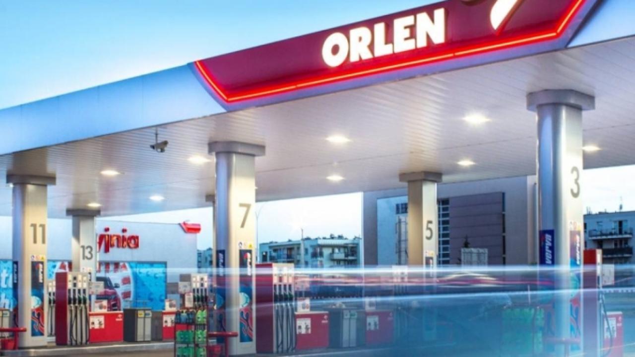 large gas station with 16 pumps and a car in spot 1