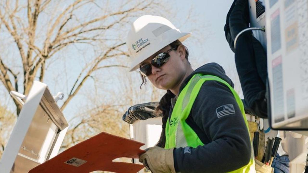 Georgia Hummel in safety wear, looking at a panel outside.