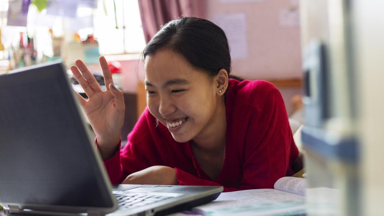 Person smiling while using a laptop
