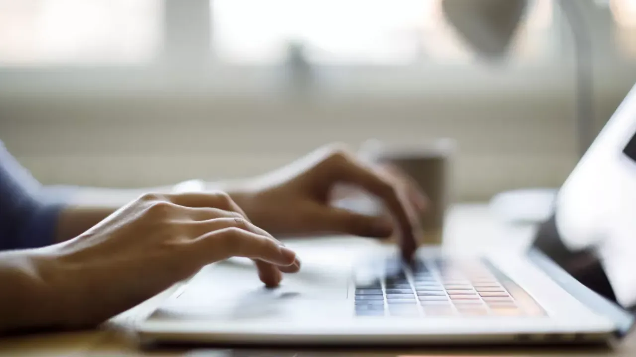 Fingers typing on a computer