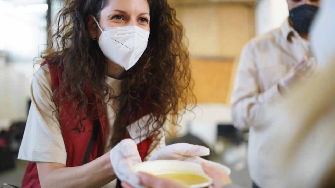 Woman in face mask serving food