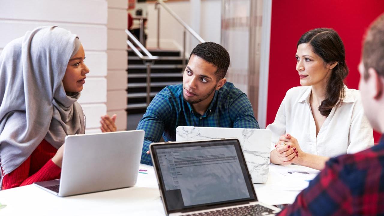 students gathered around a table in conversation
