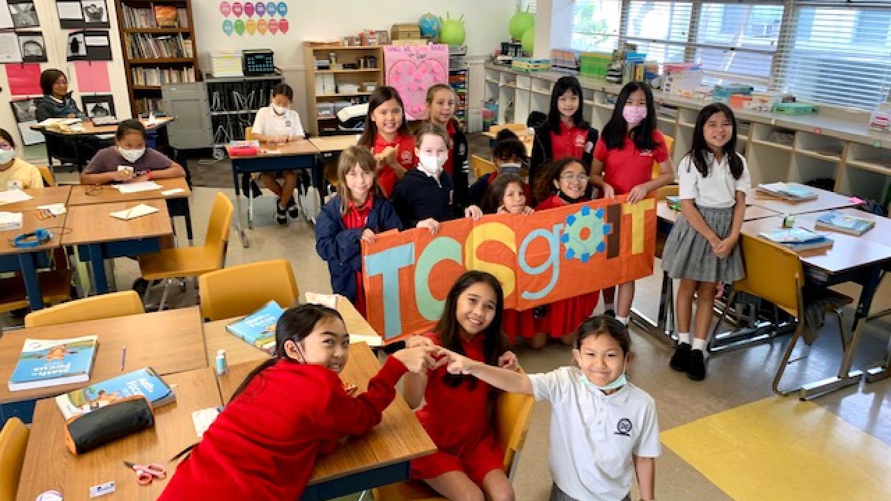 A group of school kids holding TCS goIT sign