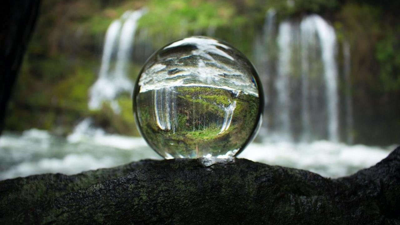 glass ball reflecting waterfall