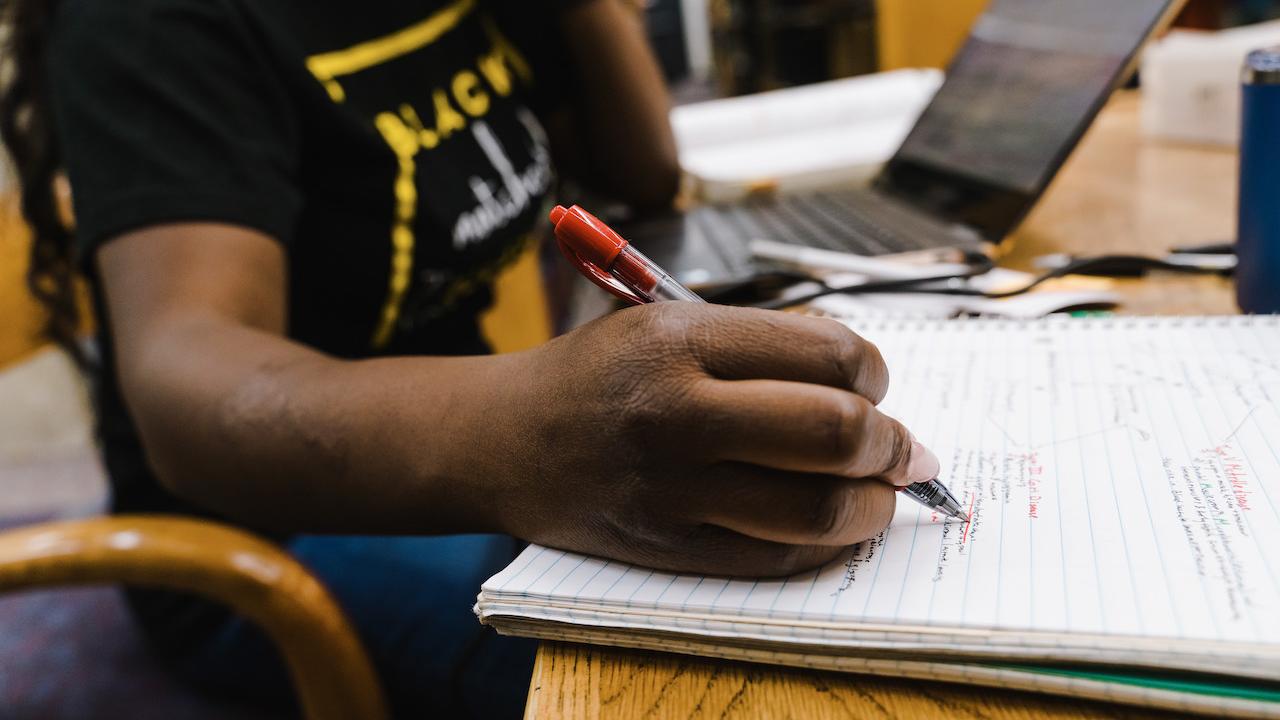 Student taking notes in a class.