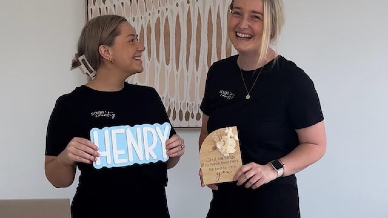 Ellie and Elyssa holding a sign.