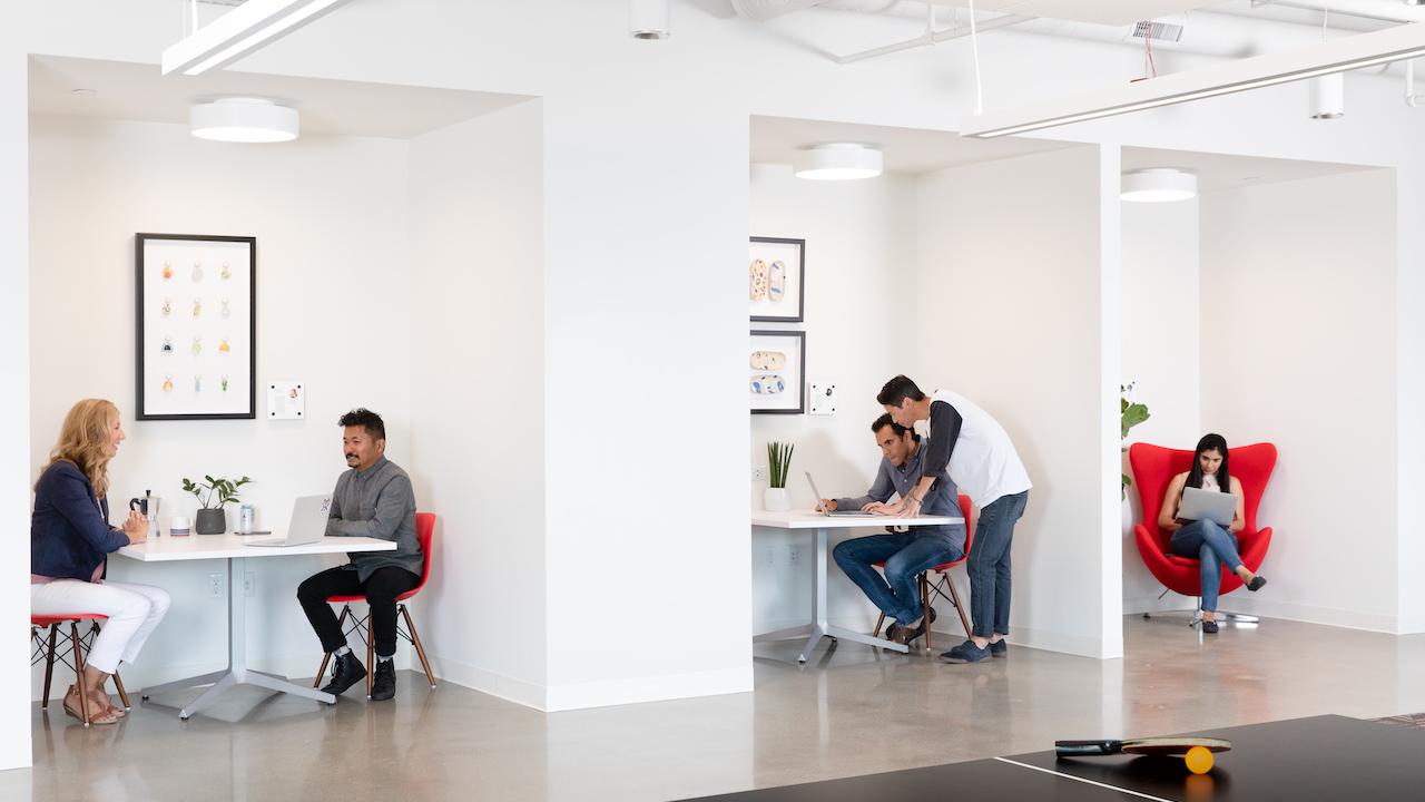 GoDaddy employees working in small groups.