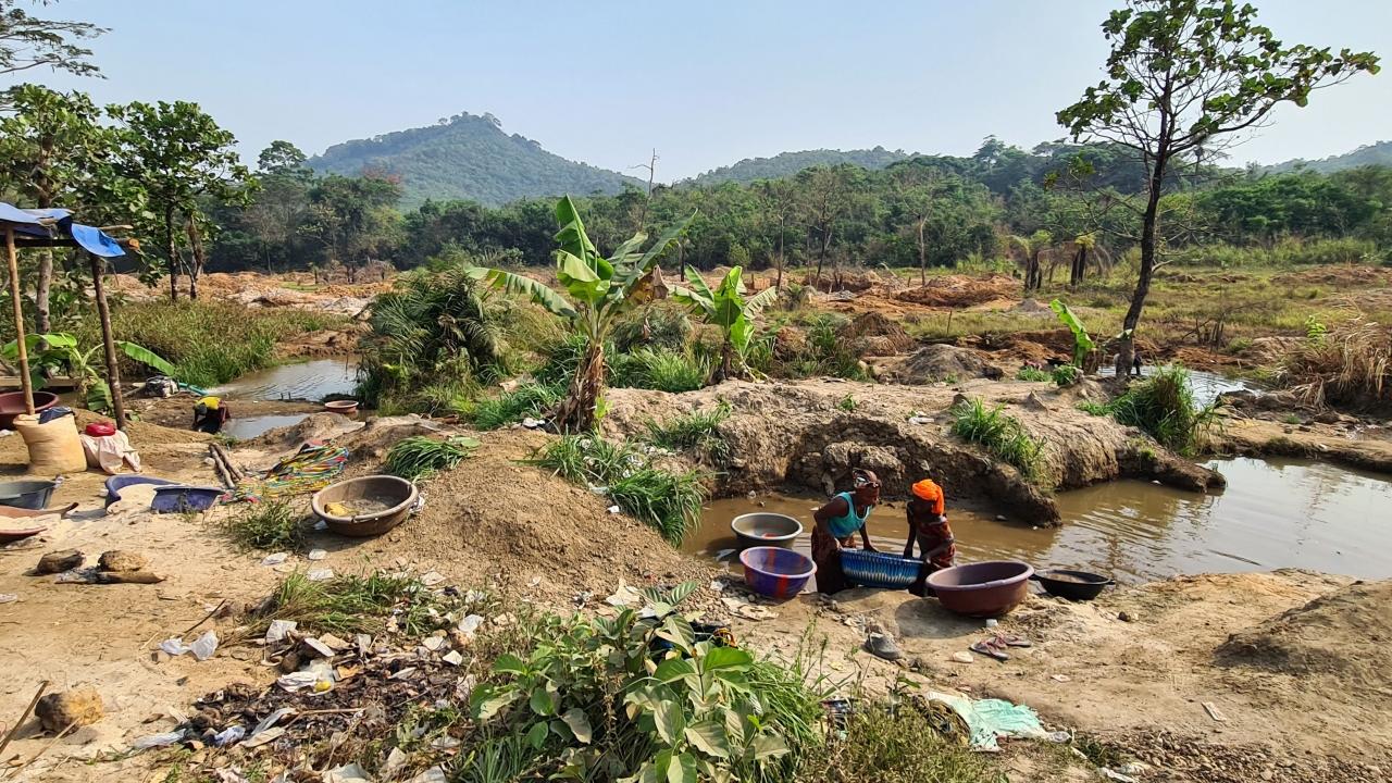 Two people pan for gold outside in Bolaneh, Sierra Leone