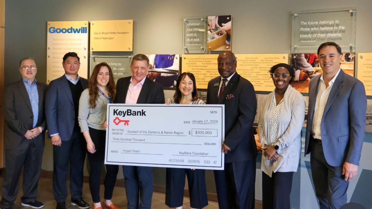 Teams from Goodwill of the Olympics and KeyBank shown with a $300,000 grant check.