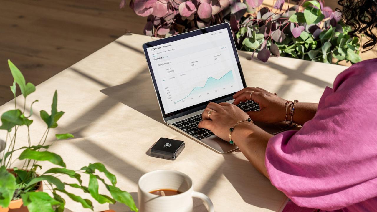 Woman seated at a desk with a laptop.