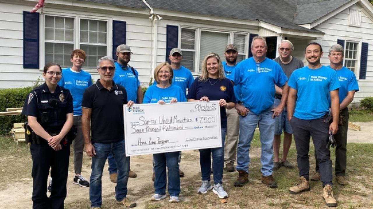 A group of people holding a large cheque 