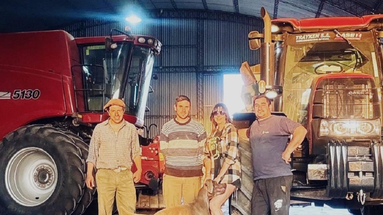 Group photo with dog in front of tractors