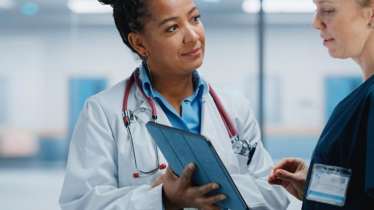 A female doctor speaking with another female doctor.