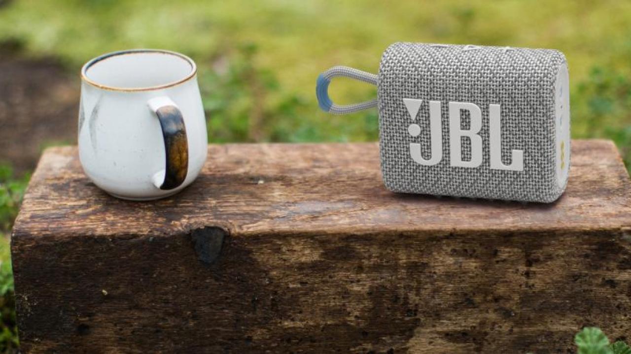 Coffee cup and JBL speaker shown in a grassy field.