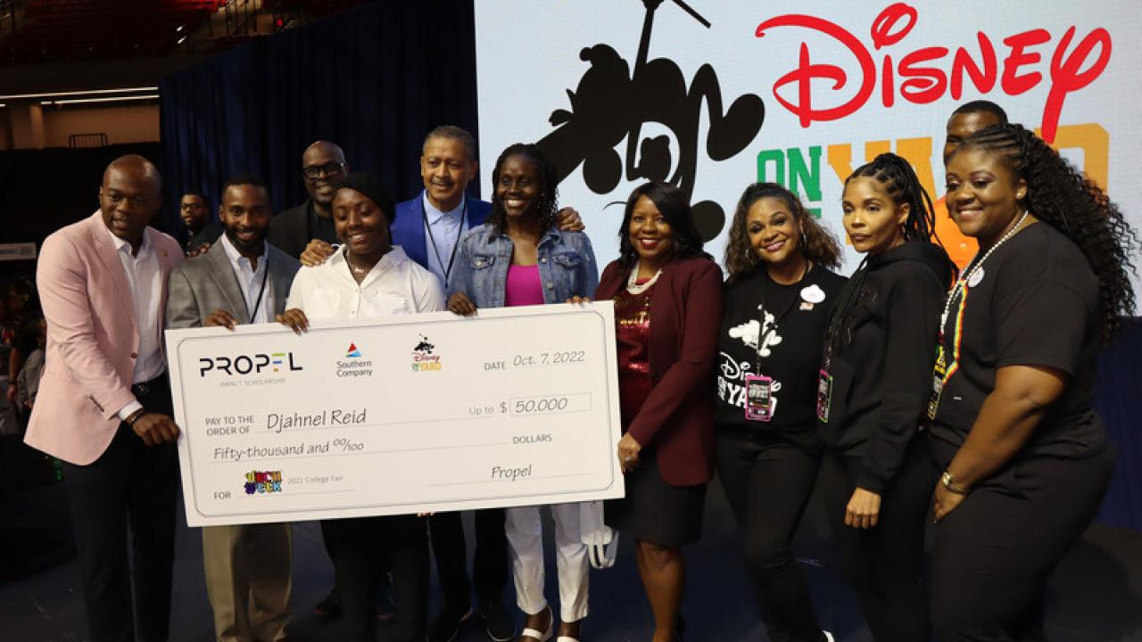 Djahnel Reid receiving a large check for her scholarship at HBCU Week event