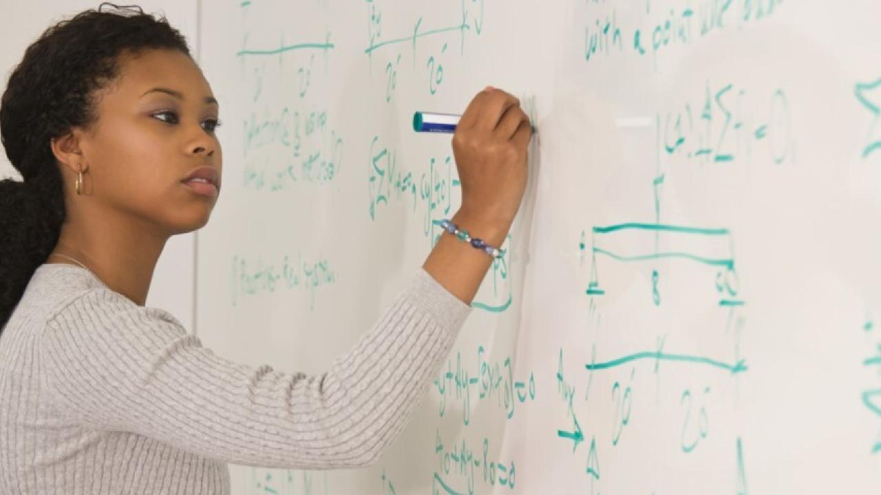 Student writing on white board