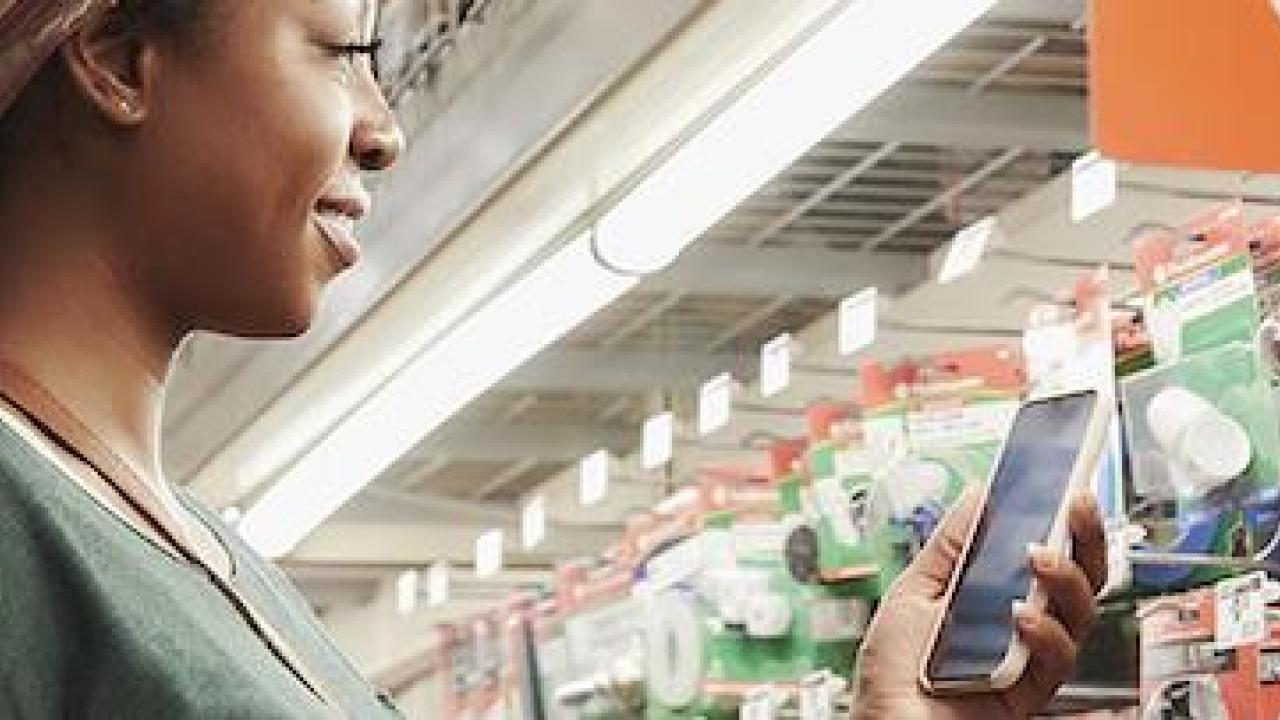 Female shopper with a smartphone using the app to shop in a Home Depot store.