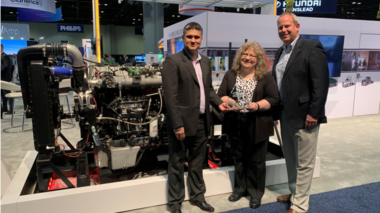 Puneet Jhawar (left) and Nick Roth (right) of Cummins accept the award from HDT’s Editor in Chief Deborah Lockridge (center) for the X15N, named one of HDT's 2022 Top 20 Products