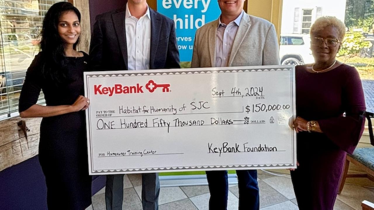 Representatives from KeyBank and Habitat for Humanity shown with a $150,000 grant check.