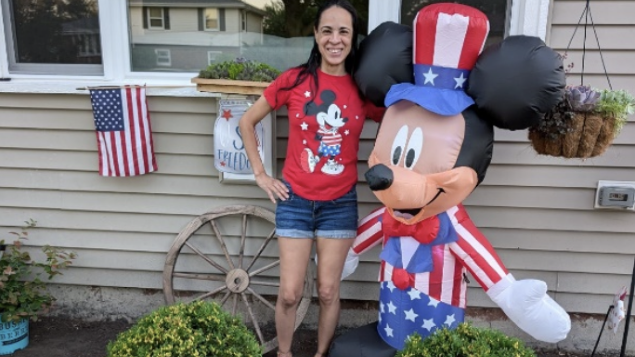 Valerie, shown with Mickey Mouse, in front of her refurbished home.