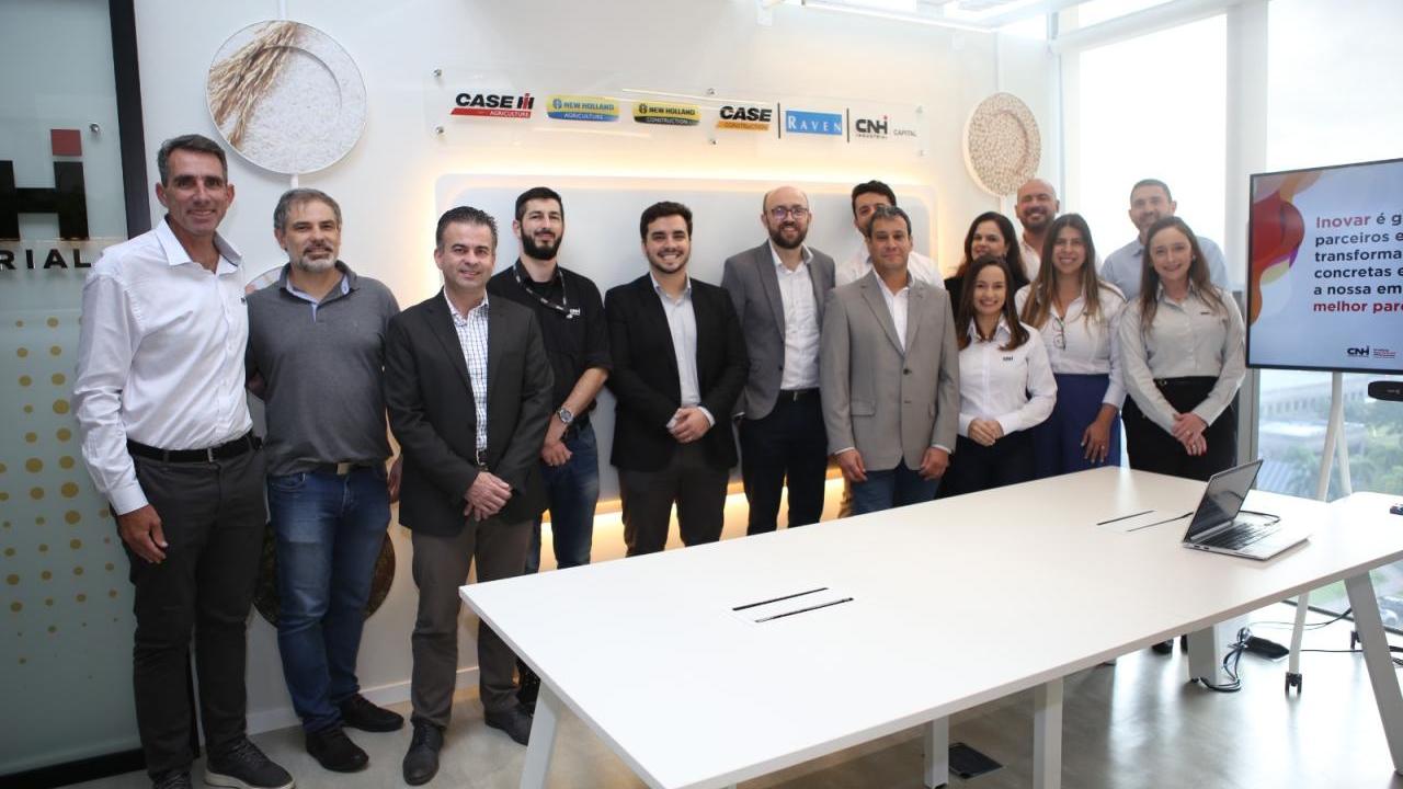 A group of people stood behind a table in an office room