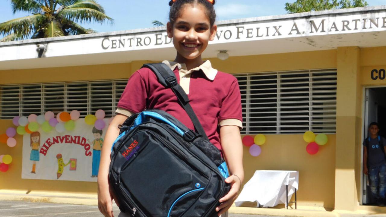Young student in front of a school in Latin America.