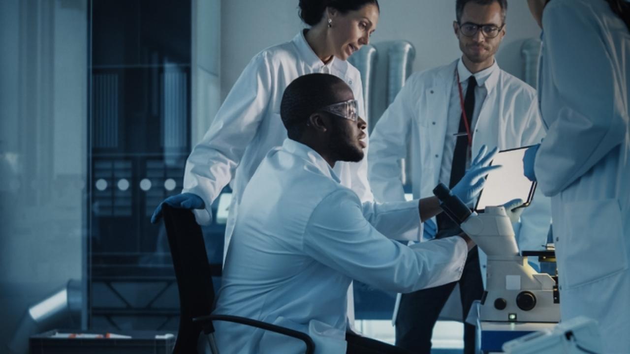 Group of four scientists working at a table.