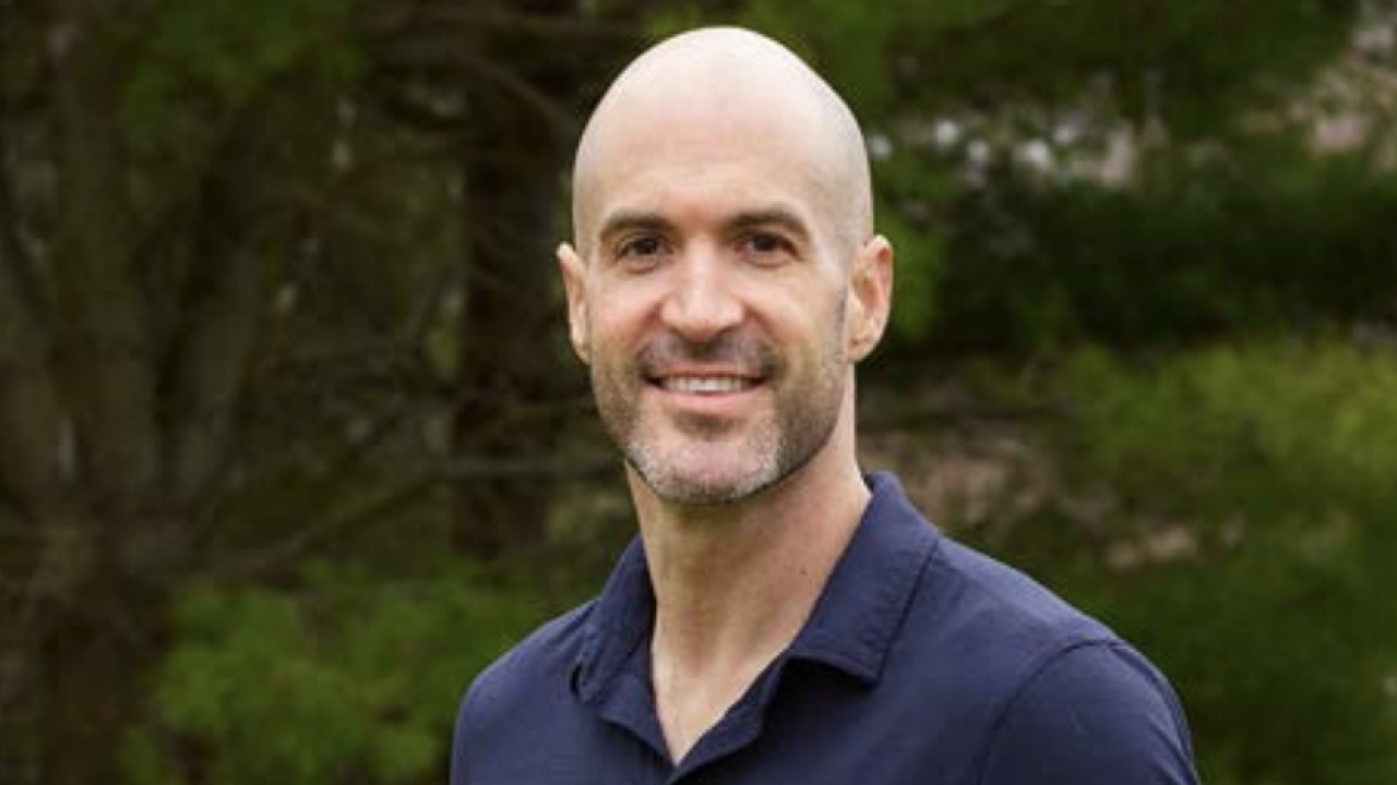 Headshot of a person stood in front of a tree