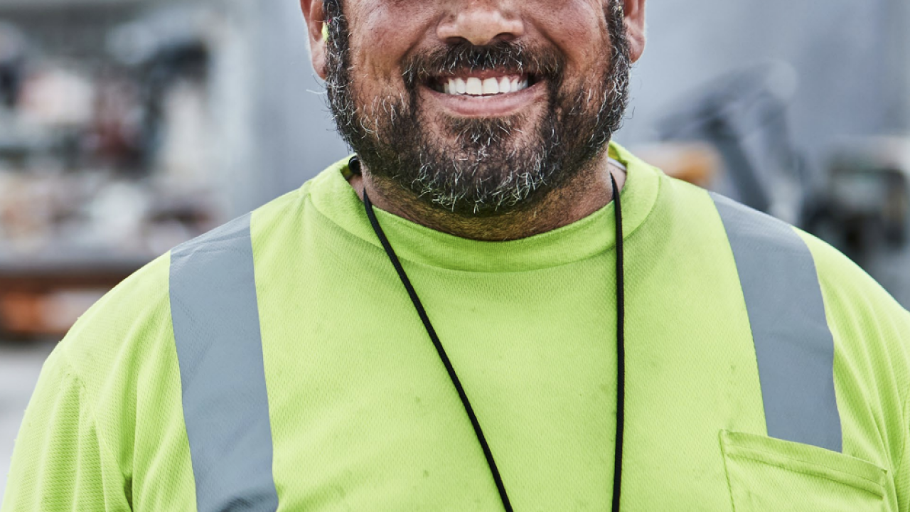 Headshot of a person wearing a FedEx hat