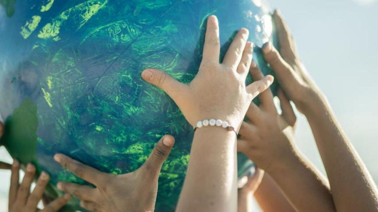 People working together to raise a large ball in the air