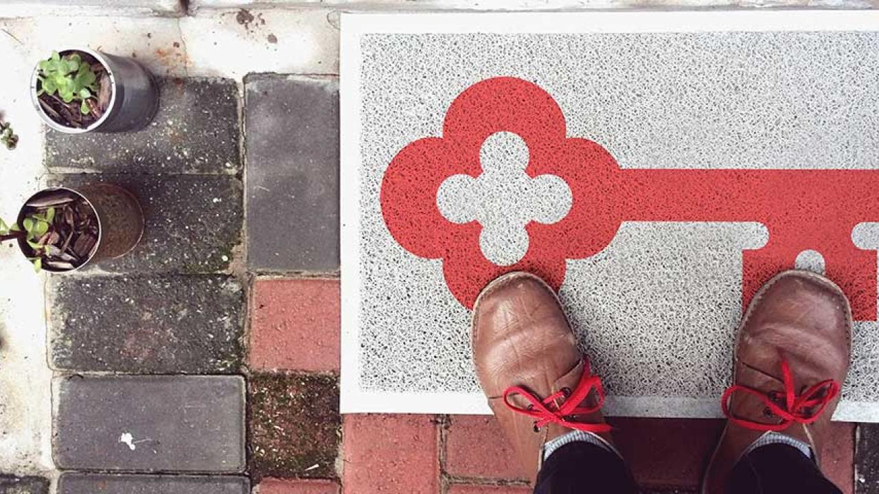 KeyBank home lending logo. Key doormat shown in front of a home.